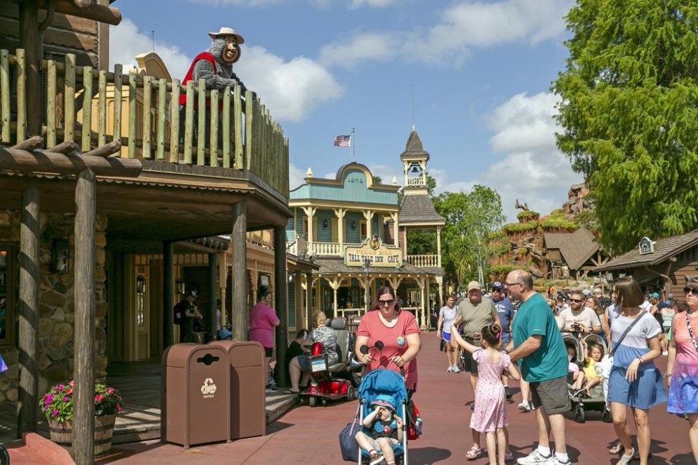 FILE - A performer dressed as a bear from the Country Bear Jamboree show entertains visitors from a deck at Magic Kingdom Park at Walt Disney World Resort in Lake Buena Vista, Florida, on April 22, 2022. It wasn't an escapee from the Country Bear Jamboree attraction, but a wild black bear managed to be the star of its own show Monday Sept. 18 2023 at Walt Disney World. The presence of the black bear in a tree in the Magic Kingdom delayed the opening of three lands Monday morning — Frontierland, Liberty Square and Adventureland. (AP Photo/Ted Shaffrey file)