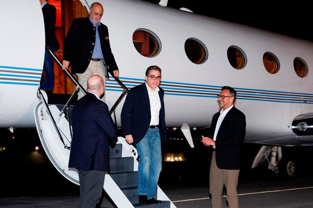 U.S. Special Presidential Envoy for Hostage Affairs Roger Carstens, right, greets freed Americans Siamak Namazi, Morad Tahbaz and Emad Shargi, as well as two returnees whose names have not yet been released by the U.S. government, who were released in a prisoner swap deal between U.S and Iran, as they arrive at Davison Army Airfield, Tuesday, Sept. 19, 2023 at Fort Belvoir, Va. (Jonathan Ernst/Pool via AP)