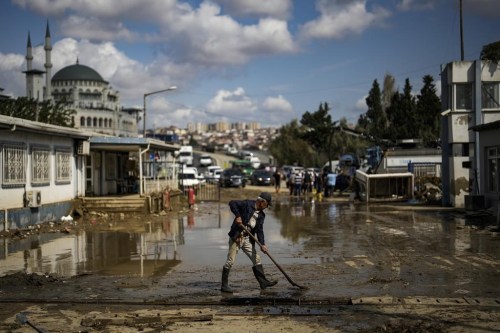 FILE - A man cleans a street on the aftermath of floods caused by heavy rains in Istanbul, Turkey, Sept. 6, 2023. Before crossing the Mediterranean, the devastating storm that dumped torrential rains along the Libyan coast raged for days and caused extensive damage in central Greece and parts of Bulgaria and Turkey, a region where such extreme storms are up to 10 times more likely and up to 40% more intense because of climate change, scientists said. (AP Photo/Khalil Hamra, File)