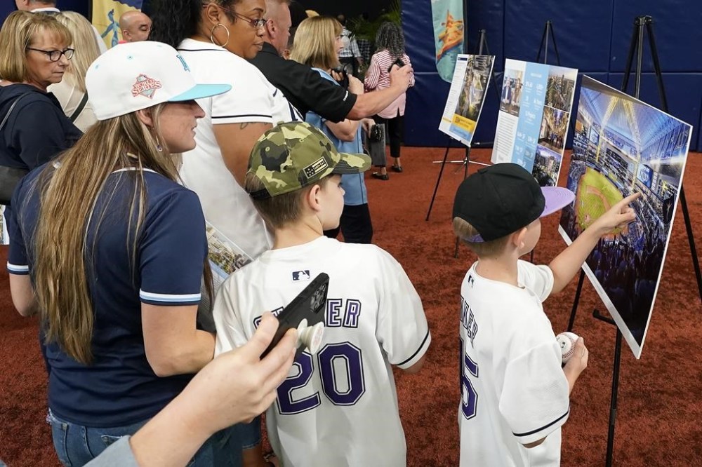Invited guests look at artist renderings of what the planned Tampa Bay Rays stadium will look like after the team announced plans for a new stadium during a news conference Tuesday, Sept. 19, 2023, in St. Petersburg, Fla. (AP Photo/Chris O'Meara)