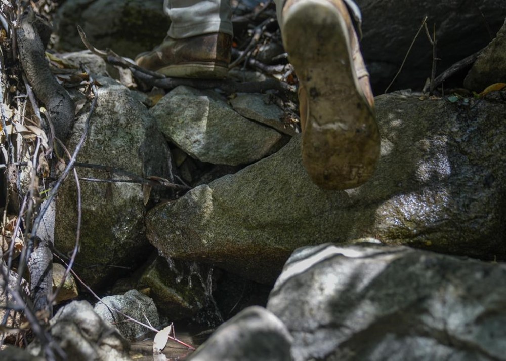 Spring water flows down rocks as activist Bridger Zadina hikes through the San Bernardino National Forest on Monday, Sept. 18, 2023, in San Bernardino, Calif. The State Water Resources Control Board is expected to vote Tuesday on whether to issue a cease-and-desist order against BlueTriton, the company that produces the widely-known Arrowhead brand of bottled water. The order would prevent BlueTriton from drawing water from certain points in the San Bernardino National Forest. (AP Photo/Ashley Landis)