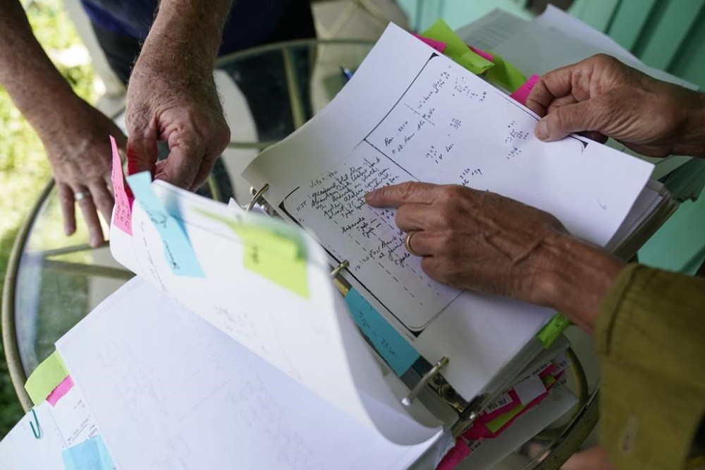 Steve Loe, a retired U.S. Forest Service biologist, and Amanda Frye, right, look through field notes from 1930, and other evidence on Friday, Sept. 15, 2023, in Redlands, Calif. The two have led efforts to stop BlueTriton, the company that produces the widely-known Arrowhead brand of bottled water, from drawing water from certain points in the San Bernardino National Forest. The State Water Resources Control Board is expected to vote Tuesday on whether to issue a cease-and-desist order against BlueTriton. (AP Photo/Ashley Landis)
