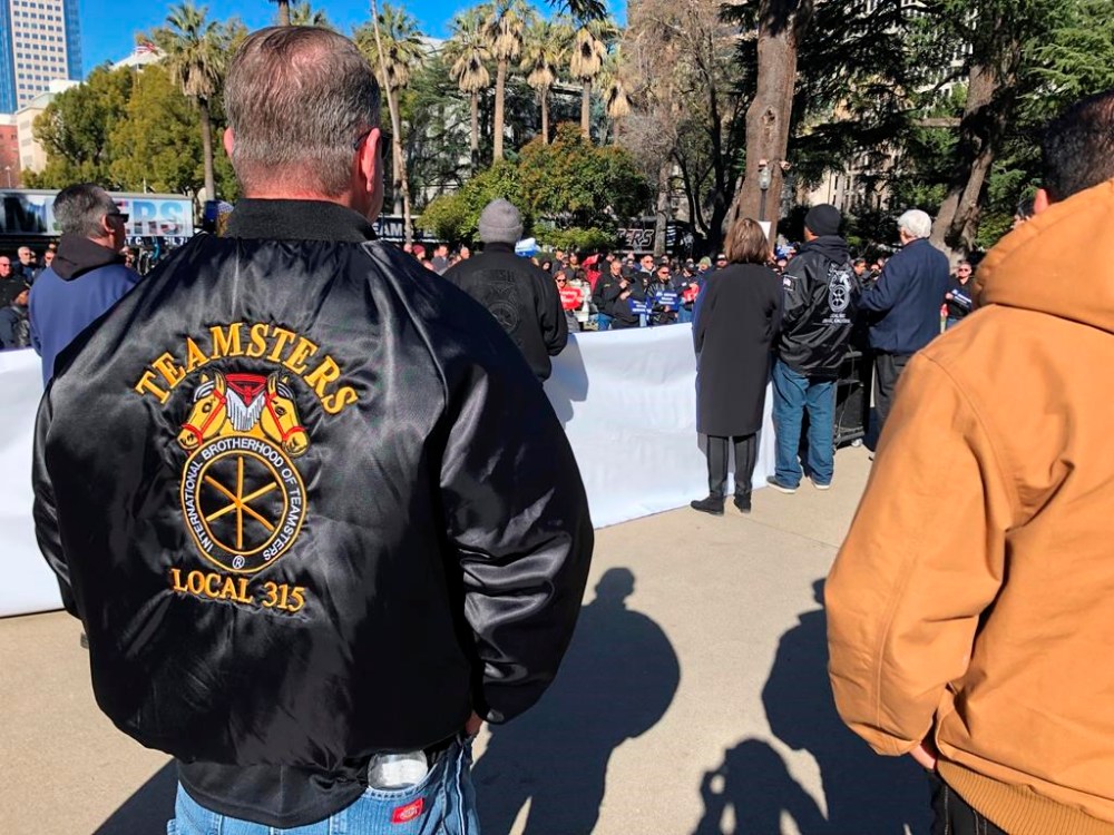 FILE - Joe Garner, a truck driver and shop steward for the local 315 of the International Brotherhood of Teamsters, watches a rally on Jan. 30, 2023, in Sacramento, Calif. Garner supports a bill that would require human drivers to be present for self-driving semitrucks. Thousands of Teamsters will caravan to the California Capitol on Tuesday, Sept. 19, 2023, to demand that Democratic Gov. Gavin Newsom sign a bill that would require self-driving semi-trucks to have a human present as they are tested on public roads for their safety. (AP/Adam Beam, File)