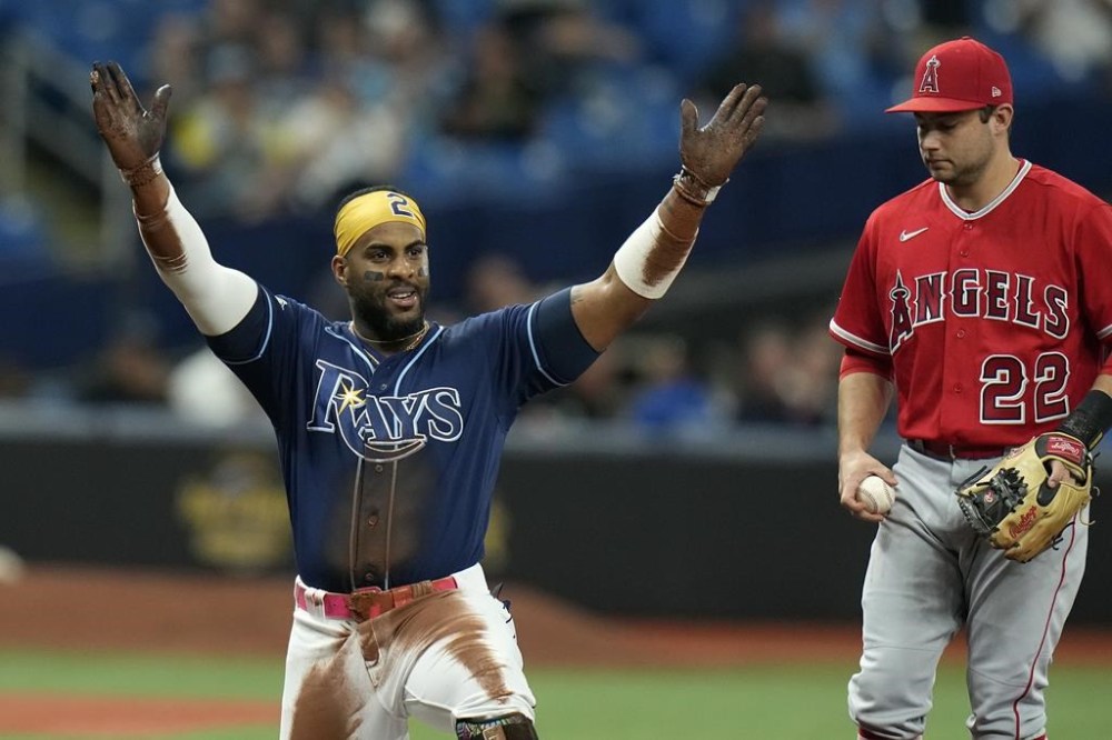 Tampa Bay Rays' Yandy Diaz (2) reacts I front of Los Angeles Angels third baseman David Fletcher (22) after hitting a triple during the first inning of a baseball game Tuesday, Sept. 19, 2023, in St. Petersburg, Fla. (AP Photo/Chris O'Meara)