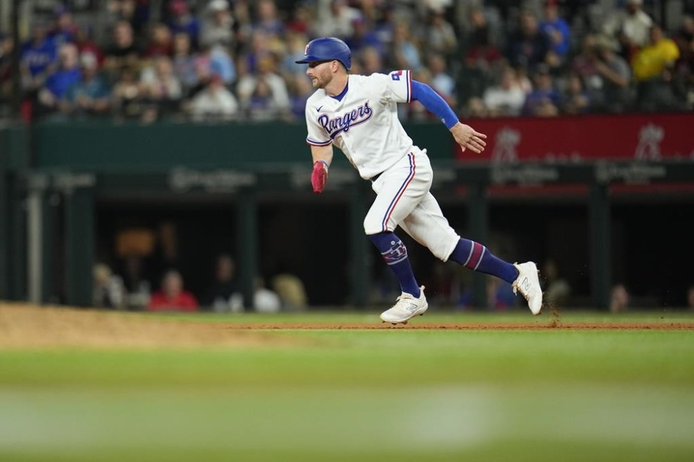 Texas Rangers' Robbie Grossman runs to second base while trying to advance on a fly out by Jonah Heim against the Boston Red Sox during the fourth inning of a baseball game, Tuesday, Sept. 19, 2023, in Arlington, Texas. (AP Photo/Julio Cortez)