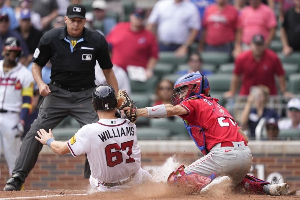 Philadelphia Phillies catcher Garrett Stubbs (21) tags out Atlanta Braves' Luke Williams (67) in the ninth inning of a baseball game against the Wednesday, Sept. 20, 2023, in Atlanta. (AP Photo/Brynn Anderson)