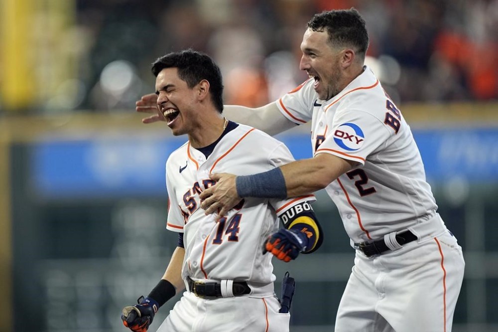 Houston Astros' Mauricio Dubon (14) celebrates with Alex Bregman (2) after hitting a game-winning RBI single during the ninth inning of a baseball game against the Baltimore Orioles Wednesday, Sept. 20, 2023, in Houston. The Astros beat the Orioles 2-1. (AP Photo/David J. Phillip)
