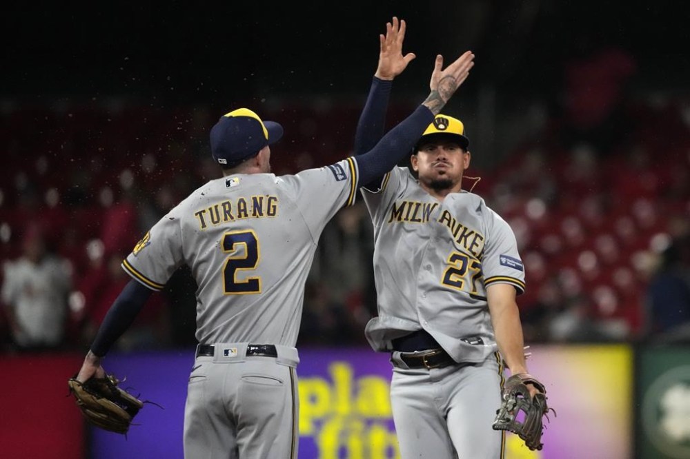 Milwaukee Brewers' Willy Adames (27) and Brice Turang (2) celebrate an 8-2 victory over the St. Louis Cardinals following a baseball game Wednesday, Sept. 20, 2023, in St. Louis. (AP Photo/Jeff Roberson)