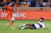 Vancouver Whitecaps midfielder Ryan Raposo, right, slide-tackles Houston Dynamo midfielder Sebastian Kowalczyk, who is struck by the ball during the first half of an MLS soccer match Wednesday, Sept. 20, 2023, in Houston. (AP Photo/Michael Wyke)
