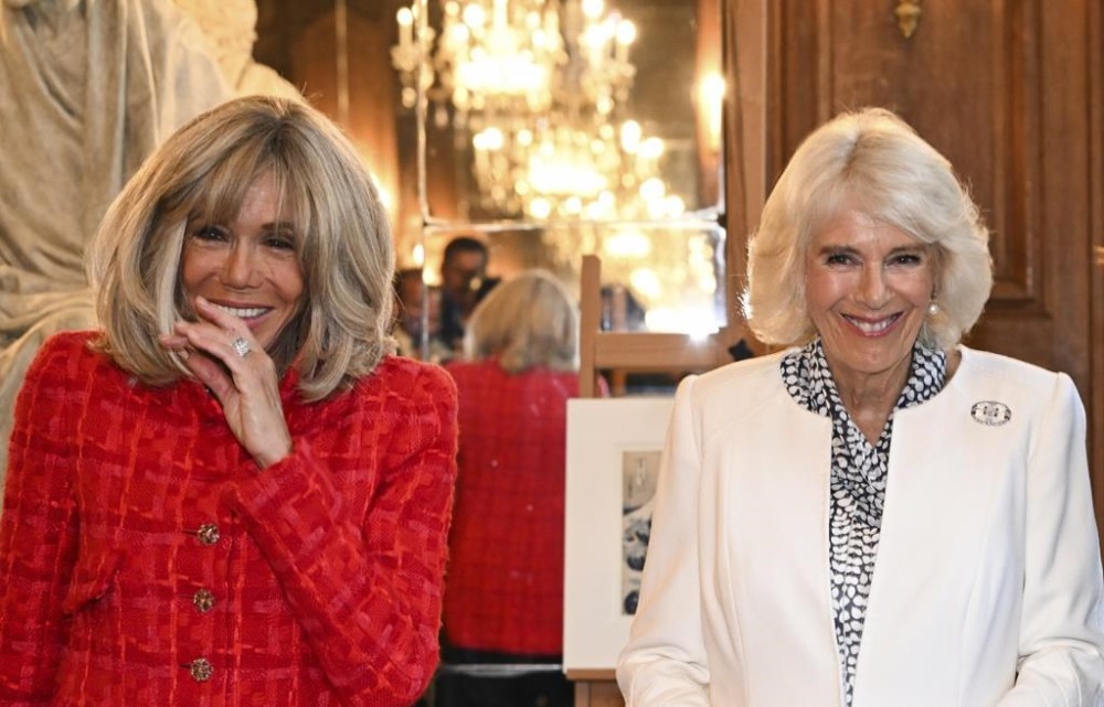French President's wife Brigitte Macron, left, and Britain's Queen Camilla smile during their visit to the