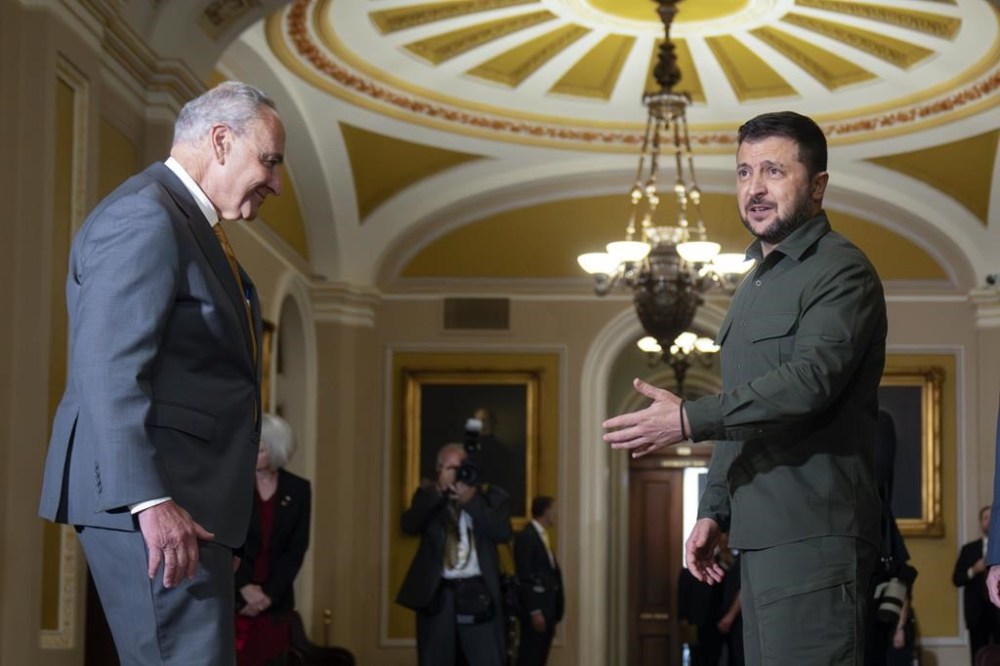 Senate Majority Leader Chuck Schumer of N.Y., left, listens as Ukrainian President Volodymyr Zelenskyy, right, speaks while walking through Capitol Hill on Thursday, Sept. 21, 2023, in Washington. (AP Photo/Mark Schiefelbein)