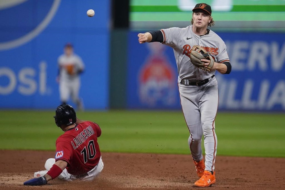CORRECTS TO BY NAYLOR, INSTEAD OF JOSH NAYLOR, WHO HIT INTO THE DOUBLE PLAY - Baltimore Orioles shortstop Gunnar Henderson throws to first after forcing out Cleveland Guardians' Ramon Laureano on a double play hit into by Bo Naylor during the second inning of a baseball game Thursday, Sept. 21, 2023, in Cleveland. (AP Photo/Sue Ogrocki)