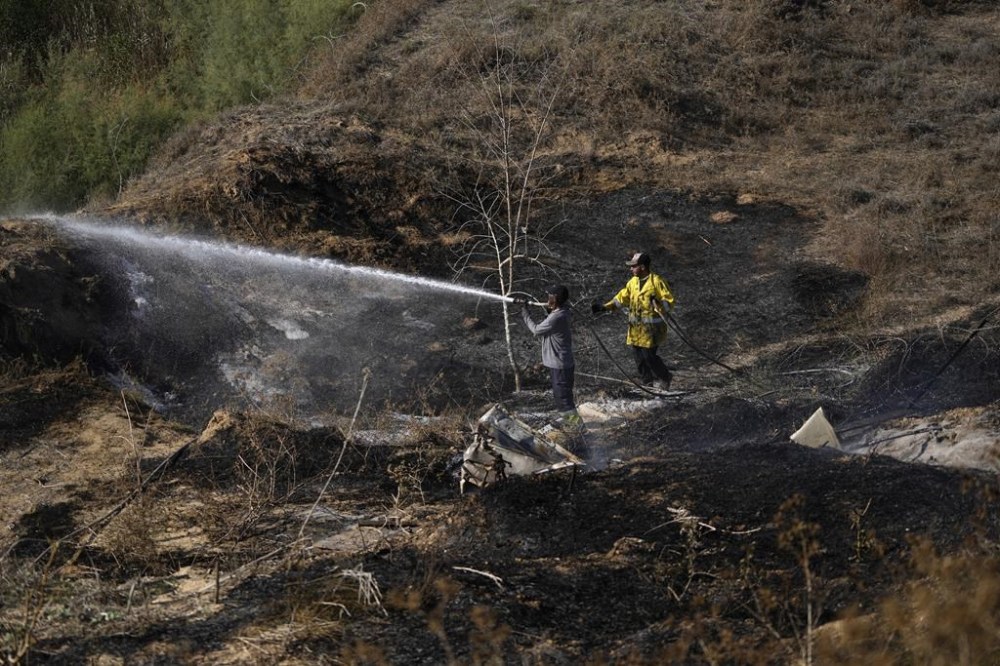 Firefighters work to extinguish fires set by incendiary ballons launched from the Gaza Strip, setting vegetation ablaze near the Israel-Gaza border, Friday, Sept. 22, 2023. Tensions between Israel and Gaza have risen in recent days as Palestinians have staged violent protests near the fence demarcating the territory. (AP Photo/Tsafrir Abayov)