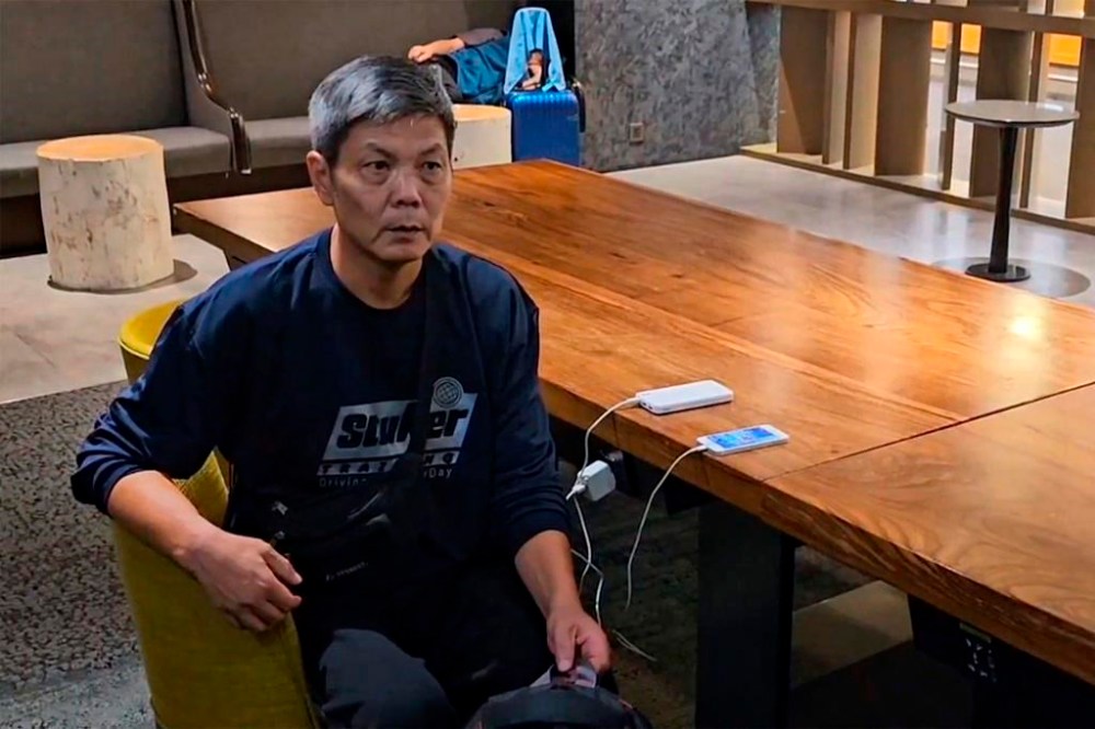 CORRECTS NAME TO CHEN - In this image taken from video footage run by TVBS, Chinese dissident Chen Siming charge his mobile phone at Taoyuan International Airport's transit lounge in Taipei, Friday, Sept. 22, 2023. Chen known for posting pictures on social media commemorating the 1989 Tiananmen Square crackdown said Friday he had fled to Taiwan and pleaded for help seeking asylum in the United States or Canada. (TVBS via AP)