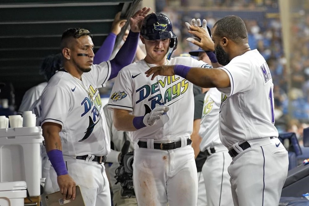 Tampa Bay Rays' Curtis Mead, center, celebrates with Isaac Paredes, left, and Manuel Margot, right, after hitting a solo home run off Toronto Blue Jays starting pitcher Chris Bassitt during the seventh inning of a baseball game Friday, Sept. 22, 2023, in St. Petersburg, Fla. (AP Photo/Chris O'Meara)