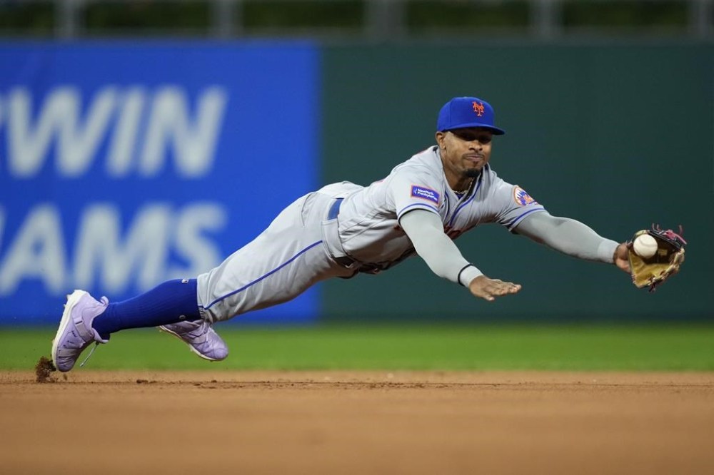 New York Mets shortstop Francisco Lindor cannot reach the throw from catcher Omar Narvaez on a stolen base by Philadelphia Phillies' Johan Rojas during the seventh inning of a baseball game, Friday, Sept. 22, 2023, in Philadelphia. (AP Photo/Matt Slocum)