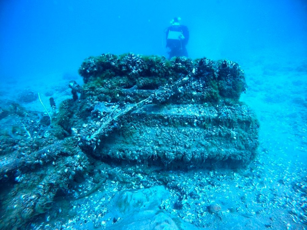 This Aug. 17, 2021 photo shows Quagga mussels cover the engine of a Bell P-39 Airacobra military plane in Lake Huron, Mich., as maritime archaeologist Carrie Sowden, rear, documents the site. Archaeologists are scrambling to locate Great Lakes shipwrecks and downed planes before quagga mussels destroy them. (Wayne Lusardi via AP)