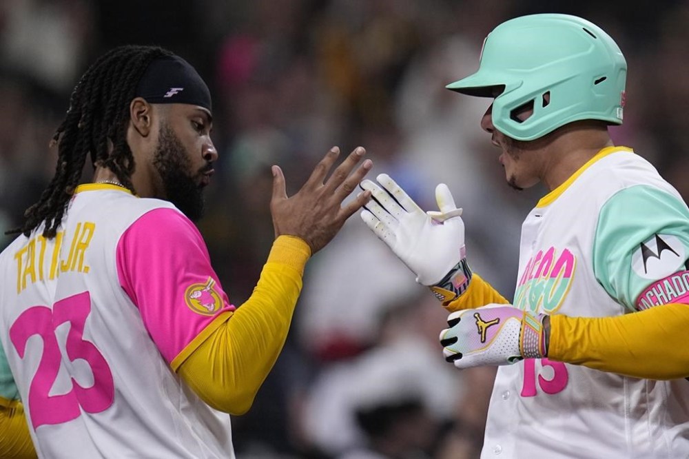 San Diego Padres' Manny Machado, right, celebrates with teammate Fernando Tatis Jr. after hitting a home run during the sixth inning of a baseball game against the St. Louis Cardinals, Friday, Sept. 22, 2023, in San Diego. (AP Photo/Gregory Bull)