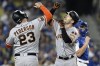 San Francisco Giants' Joc Pederson, left, celebrates with Mike Yastrzemski, front right, after Yastrzemski hit a two-run home run during the fourth inning of a baseball game against the Los Angeles Dodgers in Los Angeles, Friday, Sept. 22, 2023. Dodgers catcher Will Smith, back right, looks on. (AP Photo/Alex Gallardo)