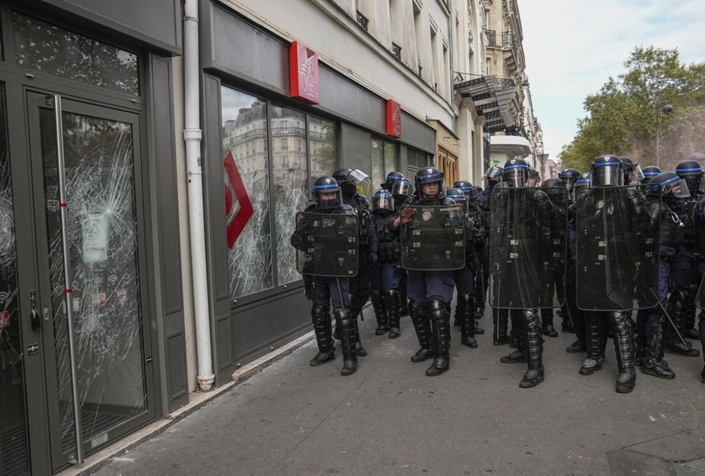 Police officers guard a bank after the window were smashed during a protest in Paris, Saturday, Sept. 23, 2023. Activists from community groups, far-left parties and unions have held marches around France against racism and police brutality. (AP Photo/Michel Euler)