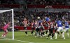 Everton's James Tarkowski, top, heads in his side's second goal of the game during the English Premier League soccer match between Brentford and Everton at the Gtech Community Stadium, in London, Saturday, Sept. 23, 2023. (Nigel French/PA via AP)