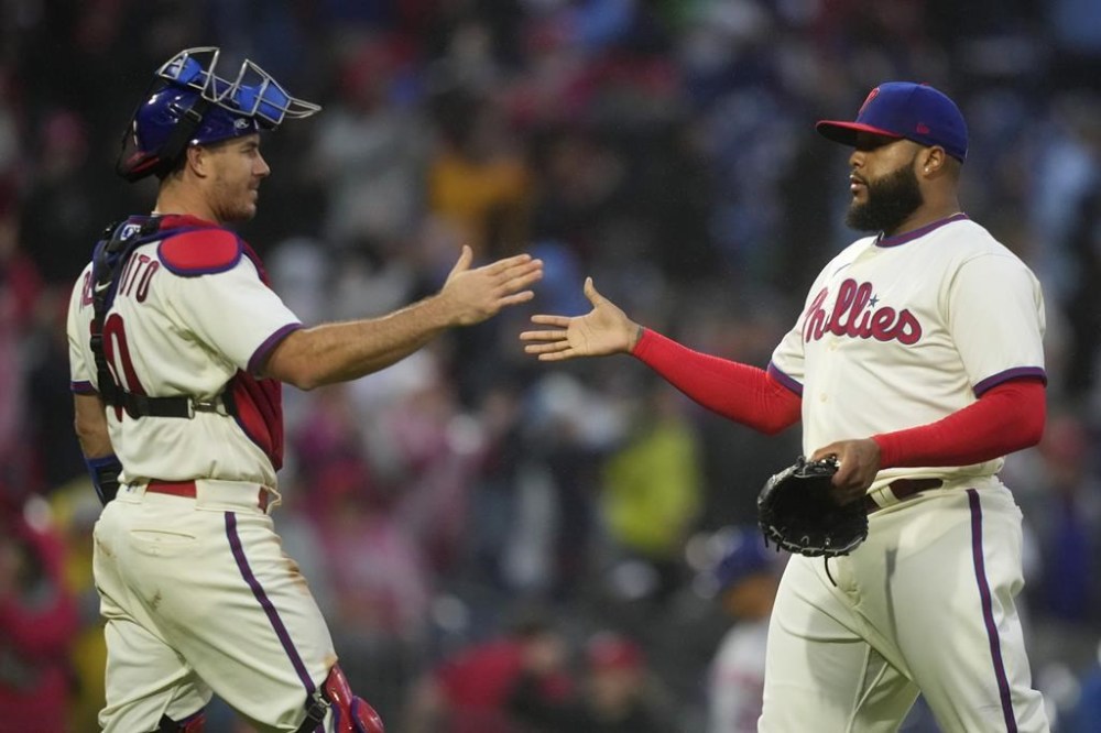 Philadelphia Phillies' Jose Alvarado, right, and J.T. Realmuto celebrate after the Phillies won a baseball game against the New York Mets, Saturday, Sept. 23, 2023, in Philadelphia. (AP Photo/Matt Slocum)