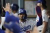 Los Angeles Dodgers' Mookie Betts celebrates in the dugout after scoring off of a double hit by designated hitter J.D. Martinez during the third inning of a baseball game against the San Francisco Giants in Los Angeles, Saturday, Sept. 23, 2023. Max Muncy also scored. (AP Photo/Ashley Landis)