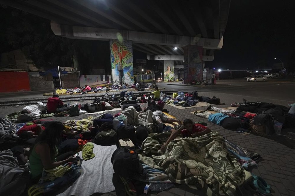 Migrants sleep outside a train station as they wait for the arrival of a northbound freight train, in Irapuato, Mexico, Friday, Sept. 22, 2023. (AP Photo/Marco Ugarte)