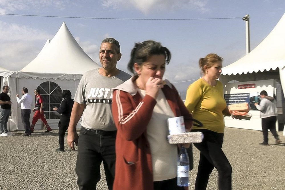 In this image taken from video, refugees from the first group of about 30 people from Nagorno-Karabakh arrive at Armenia's Kornidzor village in Syunik region, Armenia, Sunday, Sept. 24, 2023. The first refugees from Nagorno-Karabakh have arrived in Armenia, local officials reported Sunday, and more were expected to come after a 10-month blockade and a lightning military offensive this month that resulted in Azerbaijan reclaiming full control of the breakaway region. (AP Photo)