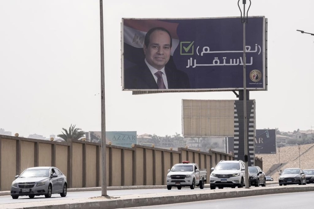 FILE - Vehicles pass under a billboard supporting Egyptian President Abdel Fattah el-Sissi for the coming presidential elections, erected by Egypt's political party of Homat Watan, the Protectors of the Nation, in Cairo, Egypt, on Sept. 4, 2023. Arabic reads,