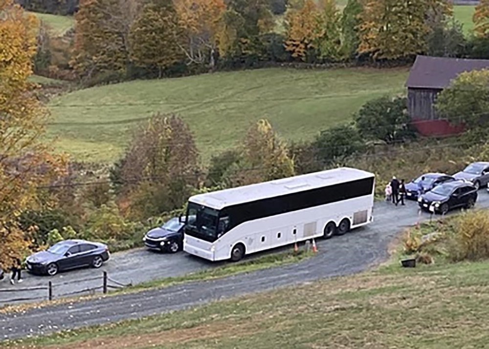 A tour bus shares a narrow road with cars outside a private property in an undated photo in Pomfret, Vt., that has become a destination for fall foliage viewers, clogging the rural road. The town is closing the road to leaf peepers through mid-October 2023 because it says the increased traffic has caused significant safety, environmental, aesthetic and quality of life issues. (AP Photo)