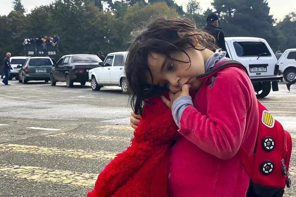 A child holds a toy as ethnic Armenians gather in hope to leave Nagorno-Karabakh region for Armenia in the center of Stepanakert, Nagorno-Karabakh on Tuesday, Sept. 26, 2023.The Armenian government said that more 6,500 Nagorno-Karabakh residents had fled to Armenia as of Monday evening. Moscow said that Russian peacekeepers in Nagorno-Karabakh were assisting the evacuation. (AP Photo/Siranush Sargsyan)