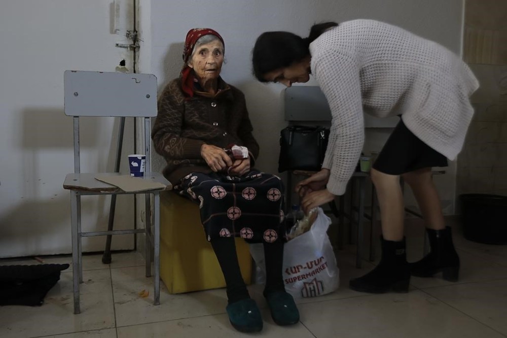An ethnic Armenian woman from Nagorno-Karabakh waits to receive humanitarian aid at a temporary camp in Armenia's Goris in Syunik region, Armenia, on Tuesday, Sept. 26, 2023. Thousands of Armenians have streamed out of Nagorno-Karabakh after the Azerbaijani military reclaimed full control of the breakaway region last week. (AP Photo/Vasily Krestyaninov)