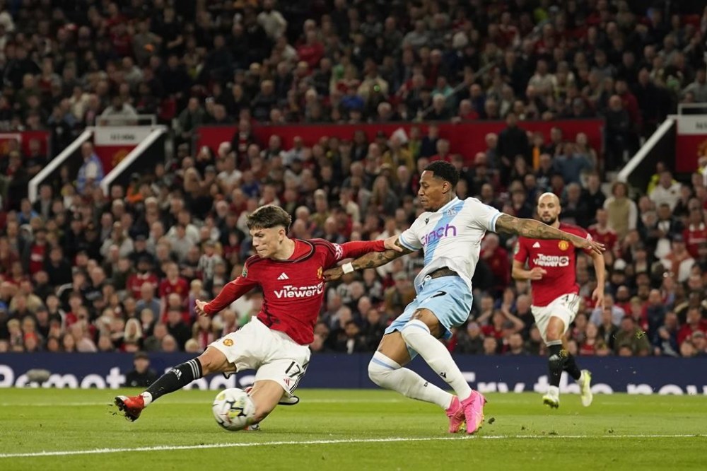 Manchester United's Alejandro Garnacho, left, scores his side's opening goal during the English League Cup third round soccer match between Manchester United and Crystal Palace at Old Trafford stadium in Manchester, England, Tuesday, Sept. 26, 2023. (AP Photo/Dave Thompson)