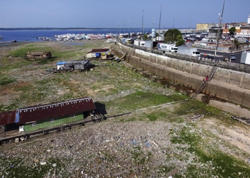 Houseboats, boats and trash lay on the now dry area that used to be covered by the Negro river, next to the pier in Manaus, Brazil, Tuesday, Sept. 26, 2023. The Brazilian Amazon rainforest is facing a severe drought that may affect around half a million people by the end of the year, authorities said Tuesday. (AP Photo/Edmar Barros)
