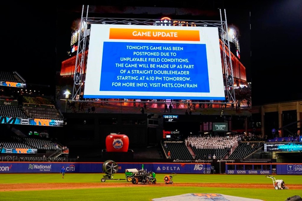 Ground crews work on the field at Citi Field after a baseball game between the New York Mets and the Miami Marlins was postponed due to unplayable field conditions Tuesday, Sept. 26, 2023, in New York. (AP Photo/Frank Franklin II)