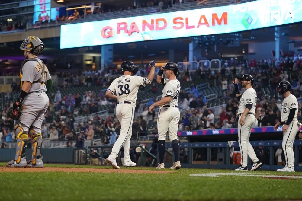 Minnesota Twins' Matt Wallner (38) celebrates with Max Kepler, center, after hitting a grand slam against the Oakland Athletics during the first inning of a baseball game Tuesday, Sept. 26, 2023, in Minneapolis. (AP Photo/Abbie Parr)