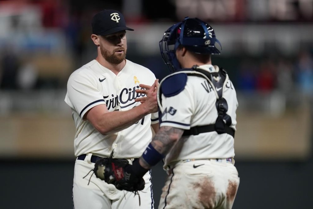 Minnesota Twins relief pitcher Brock Stewart, left, and catcher Christian Vazquez celebrate after the team's 11-3 win over the Oakland Athletics in a baseball game Tuesday, Sept. 26, 2023, in Minneapolis. (AP Photo/Abbie Parr)