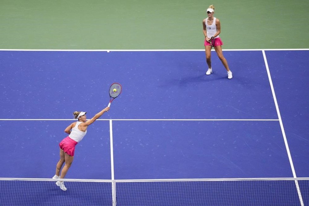 Gabriela Dabrowski, of Canada, left, returns a shot alongside doubles partner Erin Routliffe, of New Zealand, during the women's doubles final of the U.S. Open tennis championships against Laura Siegemund, of Germany, and Vera Zvonareva, of Russia, Sunday, Sept. 10, 2023, in New York. (AP Photo/Manu Fernandez)