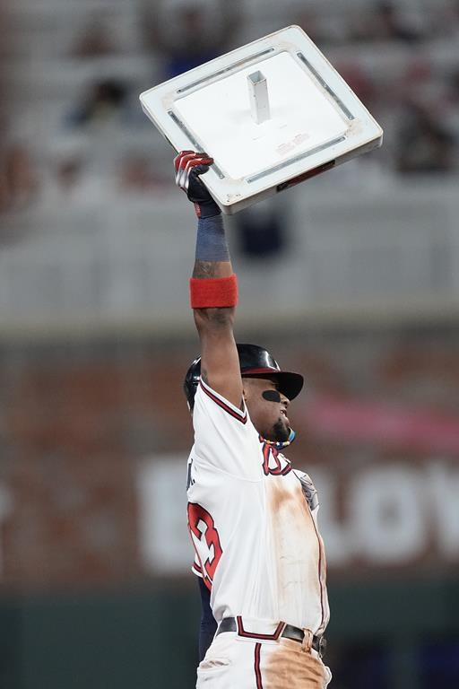 Atlanta Braves' Ronald Acuna Jr. (13) holds up the bag after stealing second base in the 10th inning of a baseball game against the Chicago Cubs, Wednesday, Sept. 27, 2023, in Atlanta. The stolen base was Acuna's 70th of the season. (AP Photo/John Bazemore)