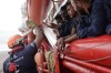 FILE - A volunteer from SOS Mediterranee makes a high five to migrant as they approach Italian coasts, on Sept. 4, 2022 off Taranto, southern Italy. The Right Livelihood Award — known as the “Alternative Nobel” — was awarded Thursday Sept. 28, 2023 to Phyllis Omido from Kenya and the groups Mother Nature Cambodia and SOS Mediterranee. (AP Photo/Jeremias Gonzalez, File)