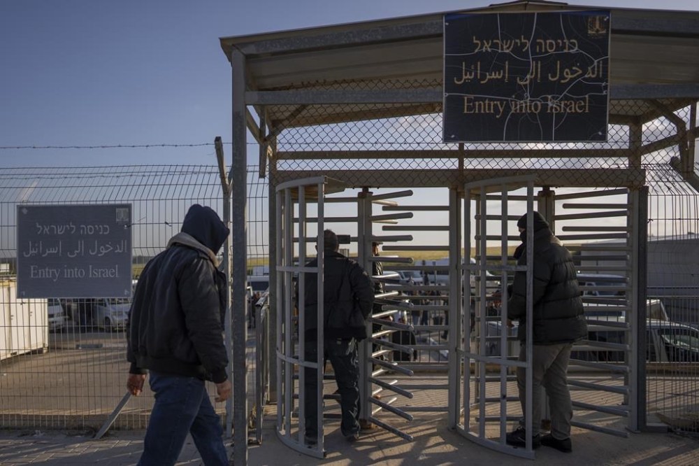 FILE - Palestinian workers enter Israel after crossing from Gaza on the Israeli side of Erez crossing between Israel and the Gaza Strip, on March 27, 2022. Israel reopened a main crossing with the Gaza Strip on Thursday, Sept. 28, 2023 allowing thousands of Palestinian laborers to enter the country for the first time since sealing it last week. (AP Photo/Oded Balilty, File)