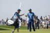Europe's Tyrrell Hatton, right hand the pin flag to his caddie Michael Donaghy on the 13th green during a practice round ahead of the Ryder Cup at the Marco Simone Golf Club in Guidonia Montecelio, Italy, Wednesday, Sept. 27, 2023. The Ryder Cup starts Sept. 29, at the Marco Simone Golf Club. (AP Photo/Alessandra Tarantino)