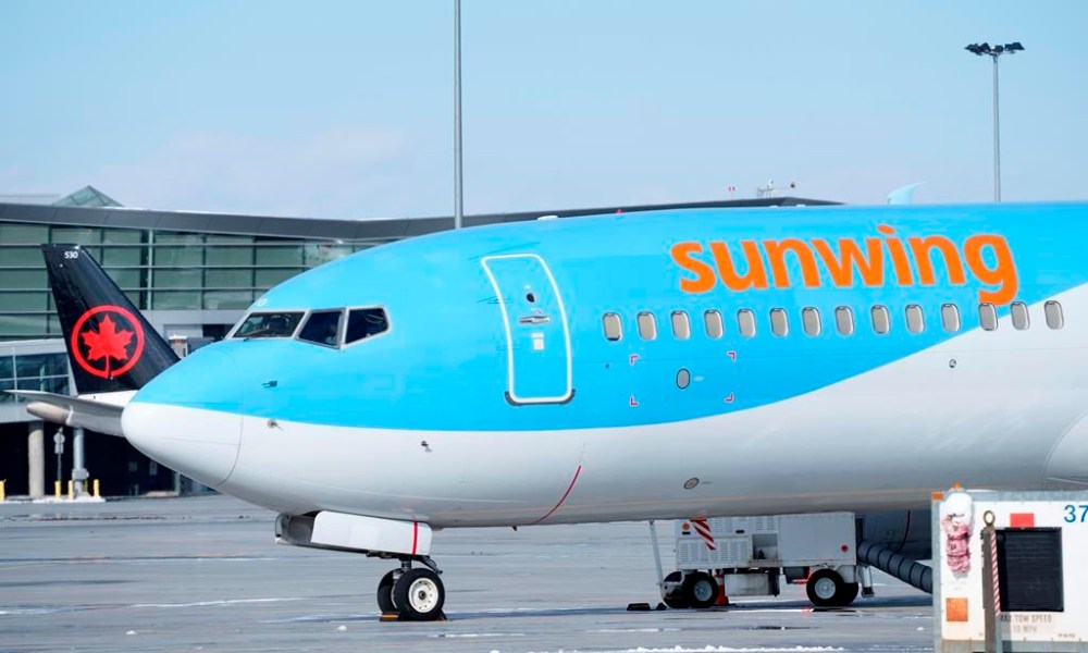 A Sunwing aircraft is parked at Montreal Trudeau airport in Montreal on Wednesday, March 2, 2022.WestJet says it aims to wind down Sunwing Airlines and integrate the low-cost carrier into its mainline business by October of next year. THE CANADIAN PRESS/Paul Chiasson