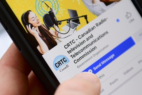 A person navigates to the on-line social-media pages of the Canadian Radio-television and Telecommunications Commission (CRTC) on a cell phone in Ottawa on May 17, 2021. THE CANADIAN PRESS/Sean Kilpatrick