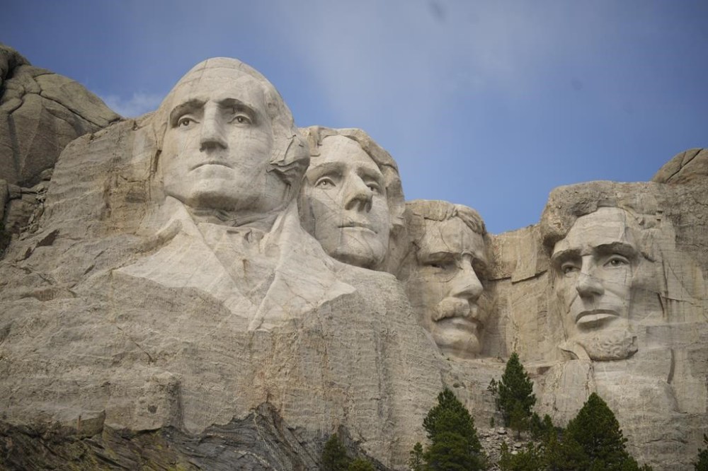 FILE - Visitors take in the massive sculpture carved into Mount Rushmore at the Mount Rushmore National Memorial Thursday, Sept. 21, 2023, in, Keystone, S.D. Gates will be locked and thousands of rangers will be furloughed from national park sites if Congress doesn’t reach a budget agreement Sunday, Oct. 1, 2023. But Arizona and Utah officials say they’ll make sure visitors can still enjoy the dramatic depths of the Grand Canyon and the soaring red cliffs of Zion Valley and South Dakota says it will pay to keep Mount Rushmore and Badlands accessible. (AP Photo/David Zalubowski, File)