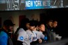 Miami Marlins' Josh Bell, second from left, stands with teammates as they watch the grounds crew members work on the field during a rain delay against the New York Mets early Friday, Sept. 29, 2023, in New York. (AP Photo/Frank Franklin II)