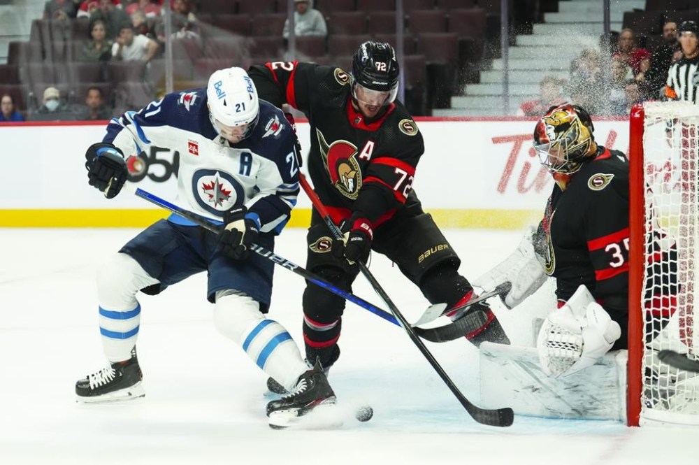 Ottawa Senators goaltender Leevi Merilainen (35) keeps his eye on the puck as Ottawa Senators defenceman Thomas Chabot (72) push Winnipeg Jets centre Dominic Toninato (21) off the net during first period pre-season NHL hockey action in Ottawa on Friday, Sept. 29, 2023. THE CANADIAN PRESS/Sean Kilpatrick