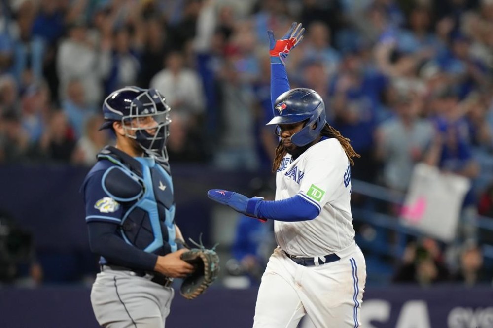 Toronto Blue Jays Vladimir Guerrero Jr. celebrates in front of Tampa Bay Rays catcher Rene Pinto as he crosses home plate to score of a two run RBI single from Toronto Blue Jays second baseman Cavan Biggio during sixth inning American League MLB baseball action in Toronto, Friday, Sept. 29, 2023. THE CANADIAN PRESS/Chris Young