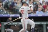 Minnesota Twins' Kyle Farmer follows the flight of his RBI single off Colorado Rockies starting pitcher Ty Blach in the first inning of a baseball game Friday, Sept. 29, 2023, in Denver. (AP Photo/David Zalubowski)